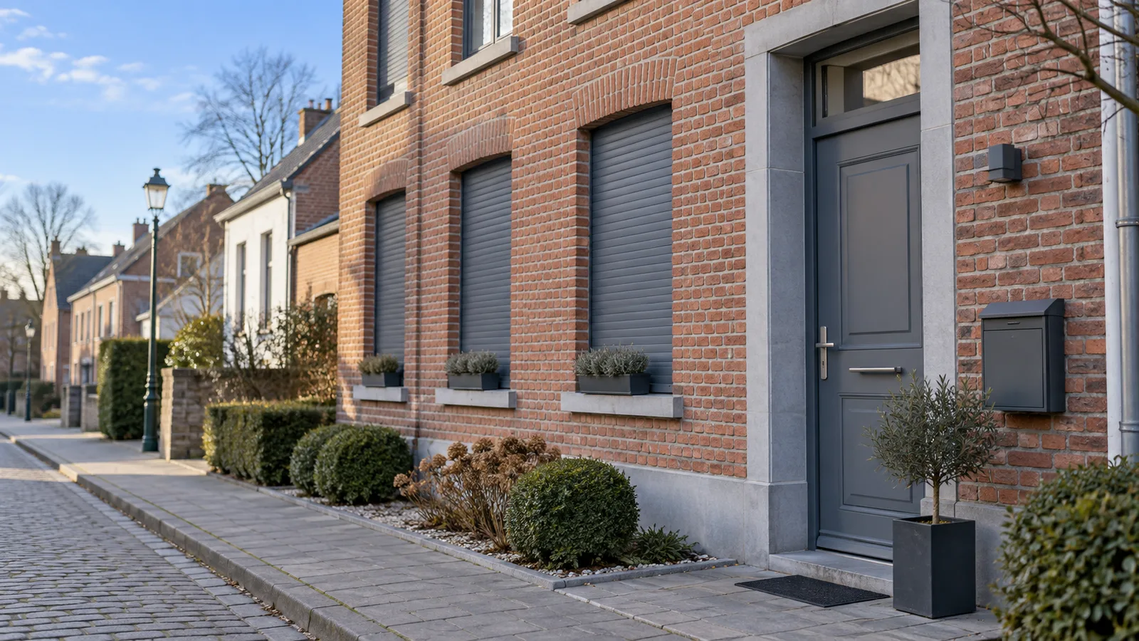 Maison de ville en brique bien entretenue, volets fermés